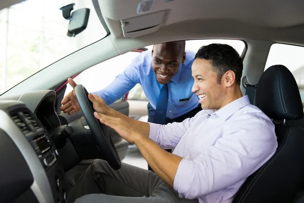 Salesman explaining car features to customer — Stock Photo, Image