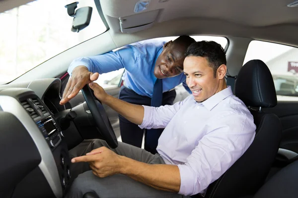 Vendedor de coches mostrando coche nuevo al cliente — Foto de Stock