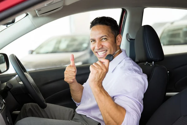 Hombre dando pulgar hacia arriba dentro de su nuevo coche — Foto de Stock