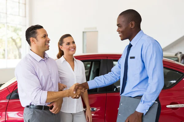 Car salesman handshaking with buyer — Stock Photo, Image