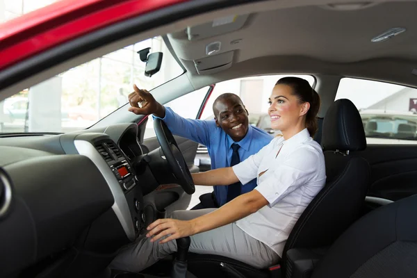 Salesman explaining car features to customer — Stock Photo, Image