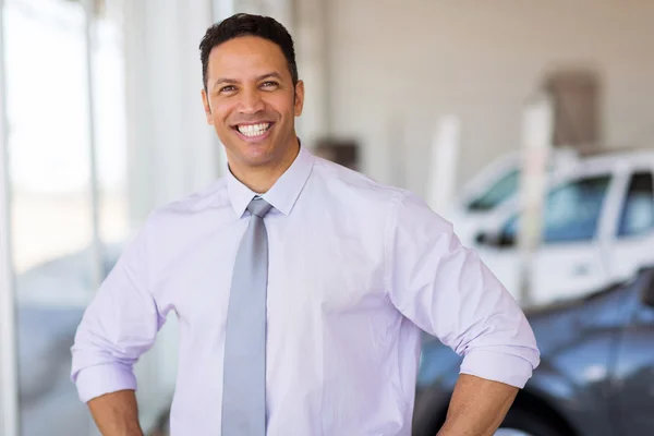 Salesman standing at car dealership — Stock Photo, Image