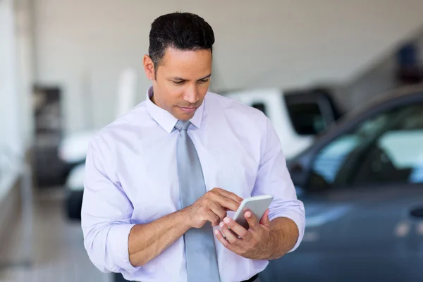 Car salesman using cell phone — Stock Photo, Image