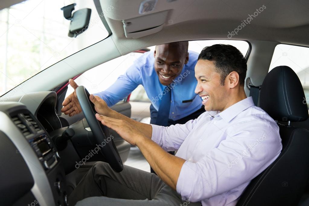 Salesman explaining car features to customer