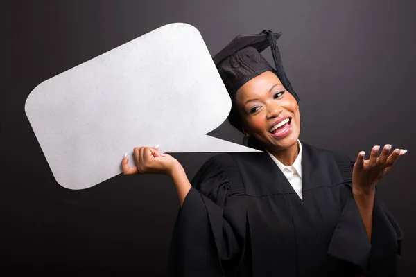 Female university graduate holding speech bubble — Stock Photo, Image