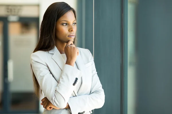 Afrikanska affärskvinna tittar genom fönstret — Stockfoto