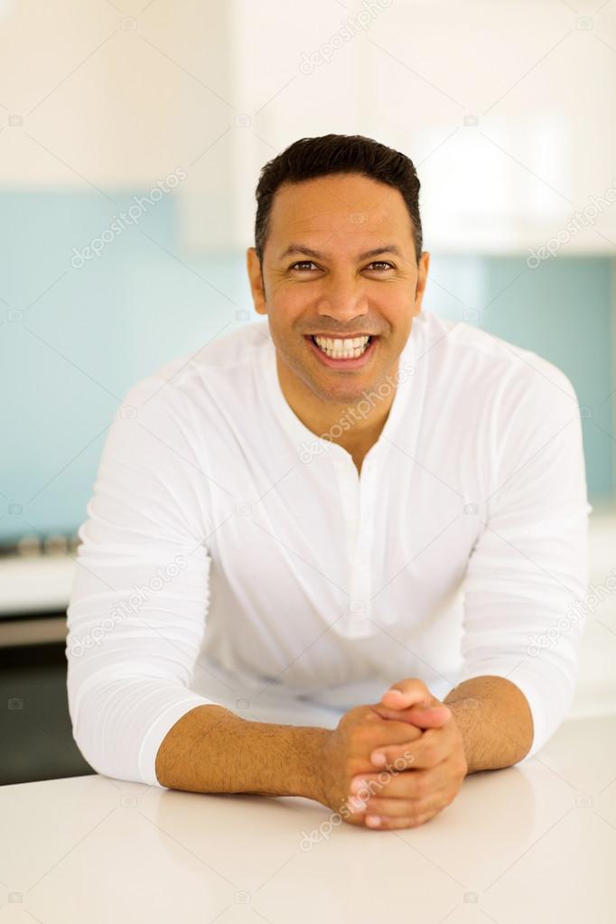 man leaning against kitchen counter