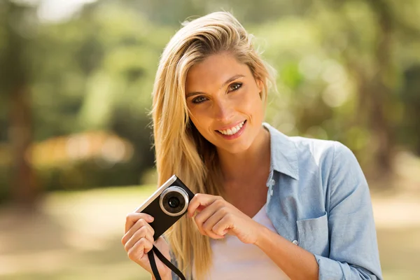 Mujer joven sosteniendo una cámara — Foto de Stock