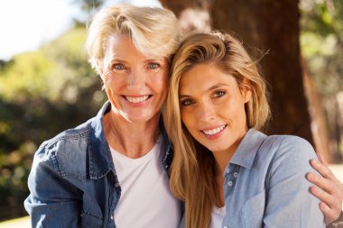mother and young adult daughter smiling