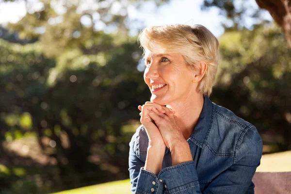 Vrouw zitten in park — Stockfoto