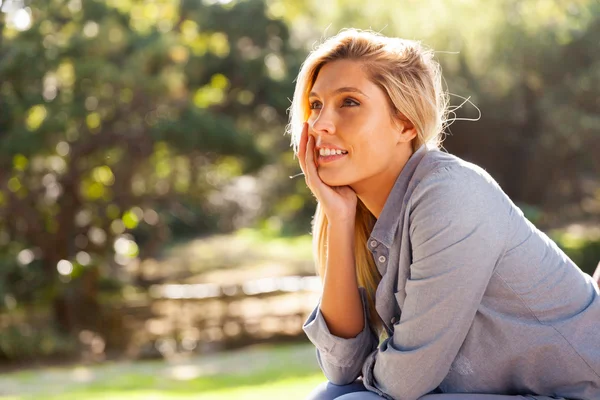 Ung kvinna sitter utomhus — Stockfoto