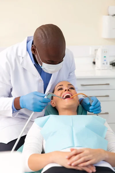 Dentist cleaning teeth of a patient — Stock Photo, Image