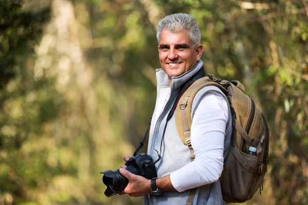 Homem caminhando com câmera dslr — Fotografia de Stock