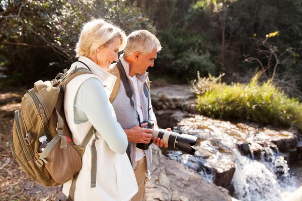 Midden leeftijd wandelaars ontspannen door rivier — Stockfoto