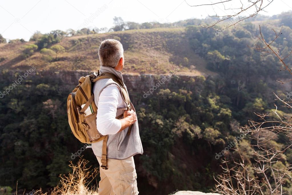 man on mountain with binoculars