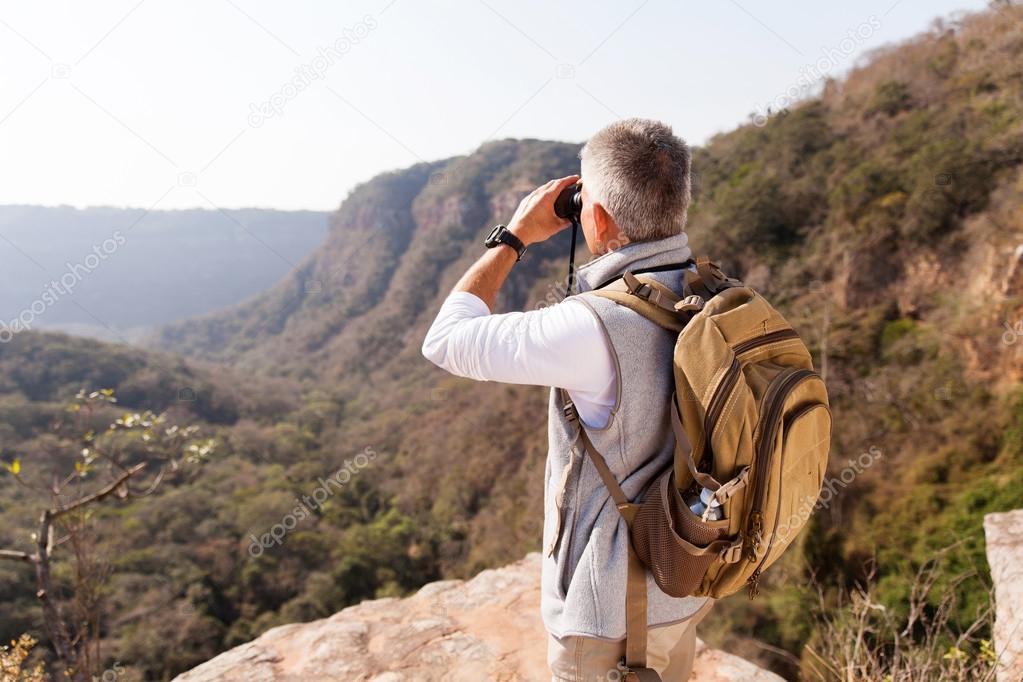 man on mountain with binoculars