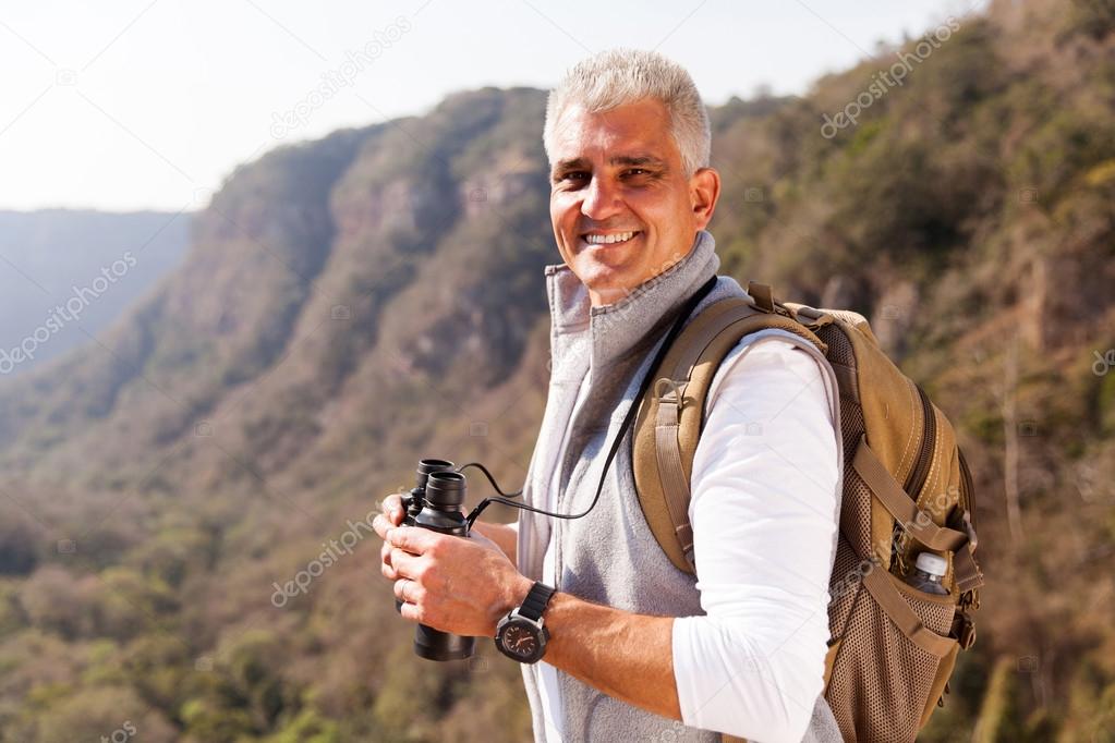 man on mountain with binoculars