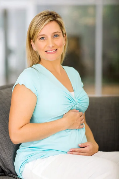 Беременная женщина на диване — стоковое фото