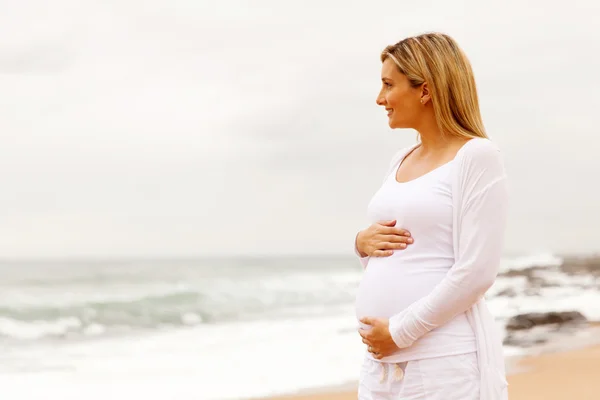 Gravid kvinna på stranden Stockbild