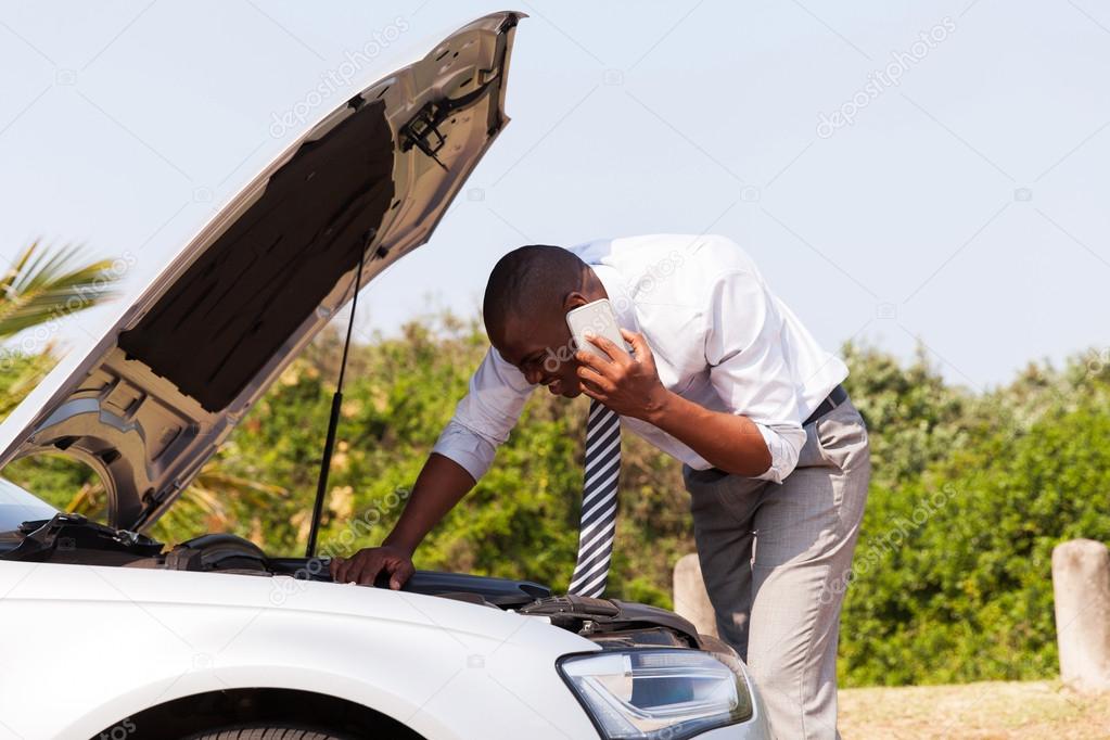 man with broken down car