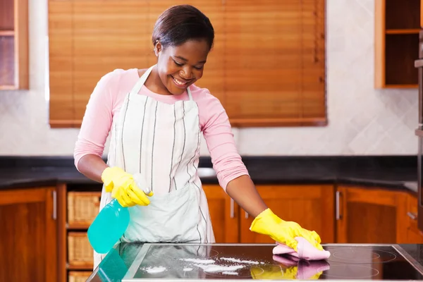 Woman cleaning stove — Stock Photo, Image