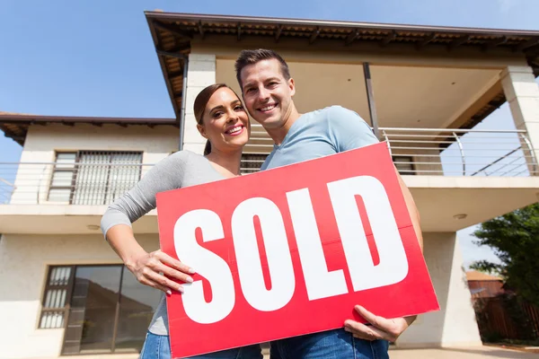 Pareja sosteniendo signo vendido — Foto de Stock