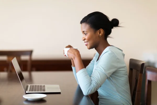 Donna che beve caffè e utilizza computer portatile — Foto Stock