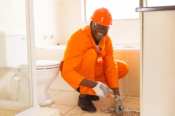 Construction worker removing floor tiles — Stock Photo, Image