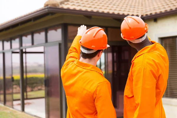 Construction workers pointing at house — Stock Photo, Image