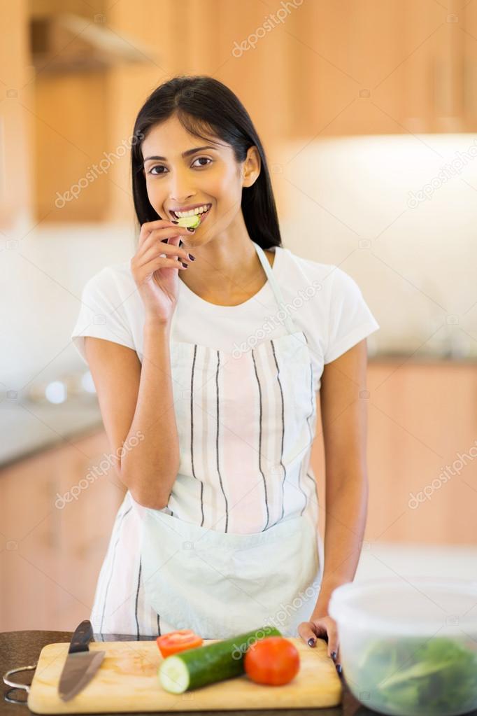 woman eating slice of cucumber