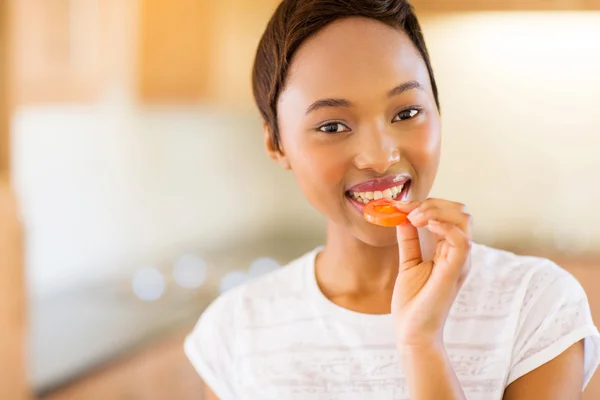 Girl eating slice of tomato — Stock Photo, Image