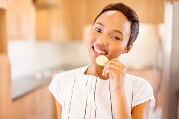 Vrouw eten plakje komkommer — Stockfoto