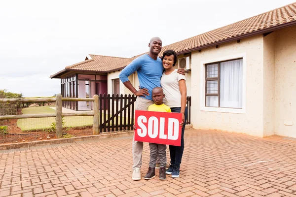 Familia cerca de casa con letrero vendido —  Fotos de Stock