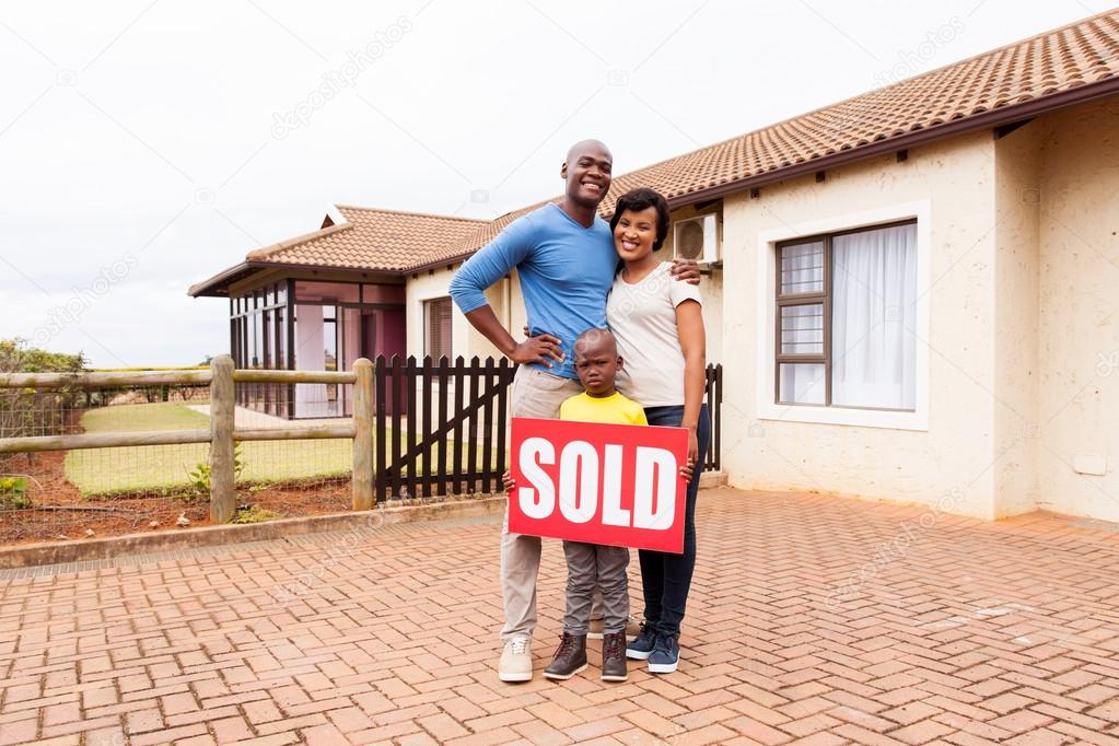 family near home with sold sign