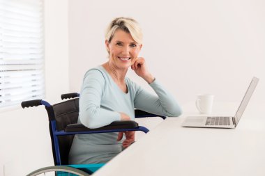 Evde dizüstü bilgisayarı olan bir kadın.