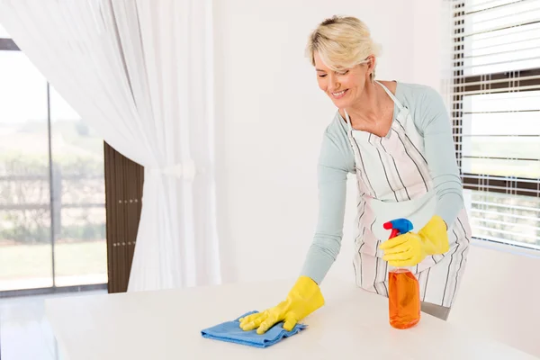Starší ženy v domácnosti utírání tabulka — Stock fotografie