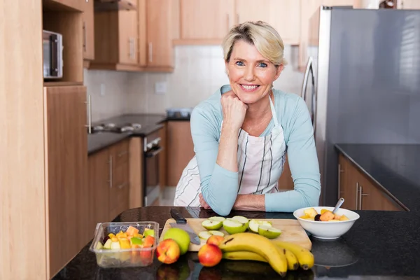 Woman leaning against kitchen counter — Stock Photo, Image