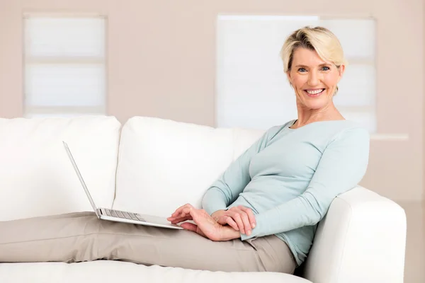 Mulher com computador portátil em casa — Fotografia de Stock