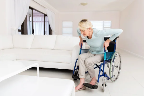 Mujer discapacitada tratando de levantarse de la silla de ruedas —  Fotos de Stock