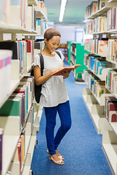 Estudante universitário leitura livro na biblioteca — Fotografia de Stock