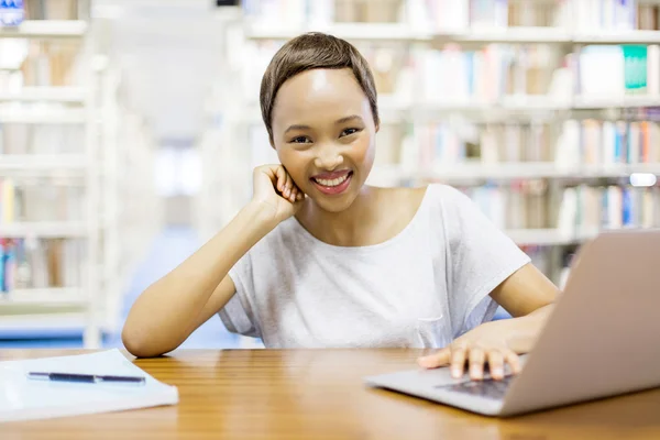 Estudante do sexo feminino estudando na biblioteca — Fotografia de Stock