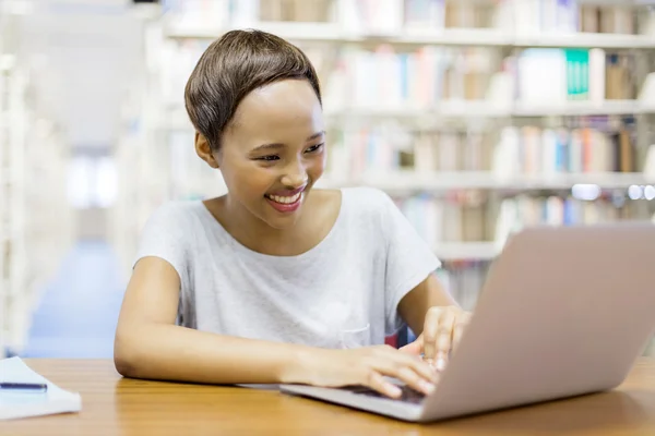 Vrouwelijke student studeert in bibliotheek — Stockfoto