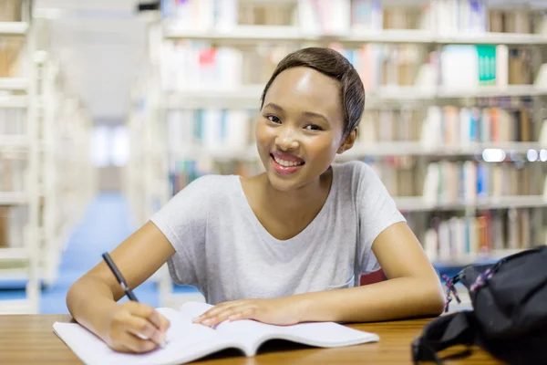 Estudiante femenina estudiando en la biblioteca —  Fotos de Stock