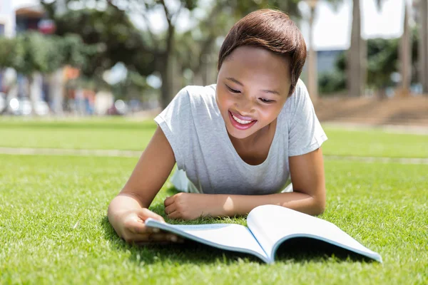 Woman lying on grass and reading book — Stock Photo, Image