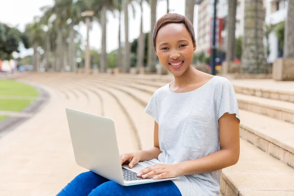 Studente con computer portatile seduto all'aperto — Foto Stock