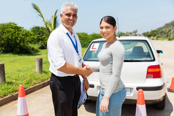 Driving instructor and learner driver handshaking — Stock Photo, Image