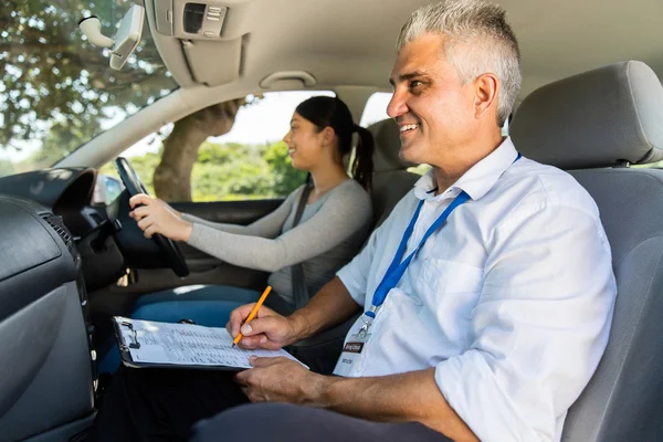 Girl taking driving test with instructor — Stock Photo, Image