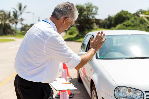 Instructor teaching learner driver to park — Stock Photo, Image