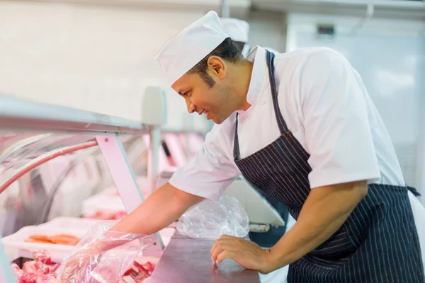 Macellaio che raccoglie carne fresca — Foto Stock