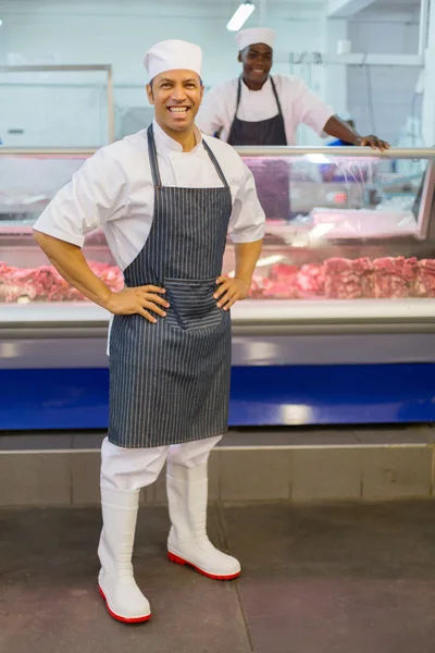 Slager met mede-werker in slagerij — Stockfoto